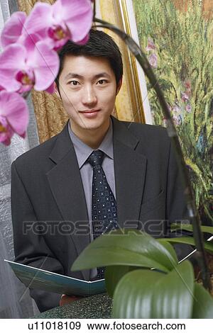 Stock Photo - Portrait of a businessman holding a file. Fotosearch
