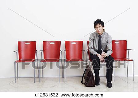 Stock Image - Portrait of a businessman holding a mobile phone. Fotosearch