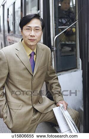Stock Photography - Portrait of a businessman holding a newspaper. Fotosearch