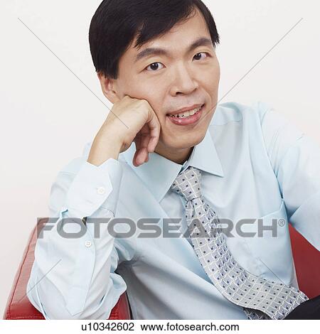 Portrait of a businessman sitting on a couch and smiling View Large Photo Image Stock Image - Portrait of a businessman sitting on a couch and smiling. Fotosearch
