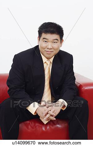 Portrait of a businessman sitting on a couch View Large Photo Image Stock Image - Portrait of a businessman sitting on a couch. Fotosearch
