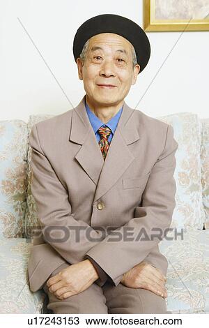 Stock Image - Portrait of a senior man sitting on a couch. Fotosearch