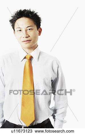 Stock Image - Portrait of a young man with his hands in his pocket. Fotosearch