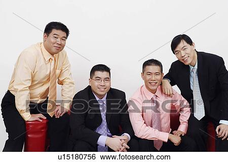 Portrait of four businessmen sitting together on a couch and smiling View Large Photo Image Stock Photograph - Portrait of four businessmen sitting together on a couch and smiling. Fotosearch