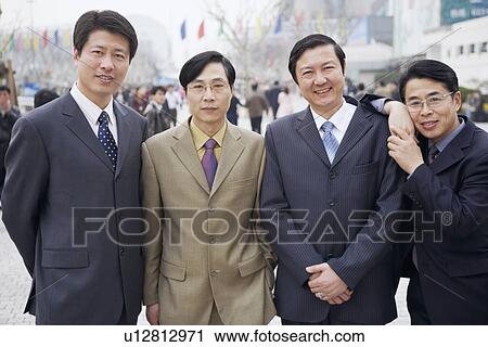 Portrait of four businessmen standing together View Large Photo Image Stock Image - Portrait of four businessmen standing together. Fotosearch