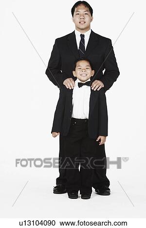 Stock Image - Portrait of two brothers standing together smiling. Fotosearch