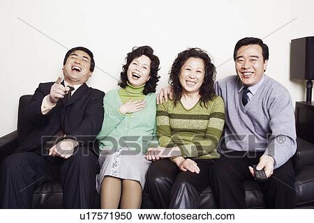Portrait of two mature couples sitting together on a couch smiling View Large Photo Image Stock Image - Portrait of two mature couples sitting together on a couch smiling. Fotosearch