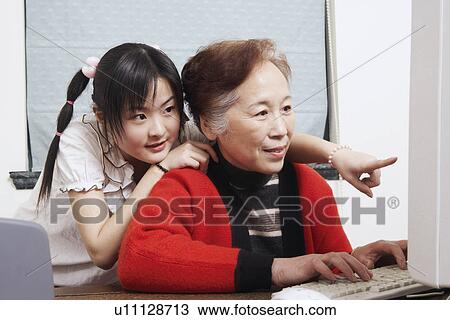 Stock Image - Close-up of a grandmother and her granddaughter using a computer. Fotosearch