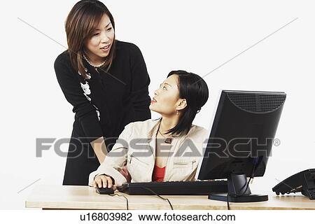 Stock Image - Close-up of two businesswomen looking at each other. Fotosearch