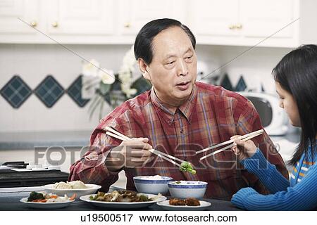 Stock Photo - Grandfather and his granddaughter sitting at a table. Fotosearch