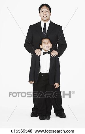Stock Photo - Portrait of a brother standing with his hands on his brother's shoulders. Fotosearch