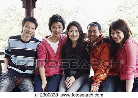 Stock Photo - Portrait of a teenage boy sitting together with his friends smiling. Fotosearch