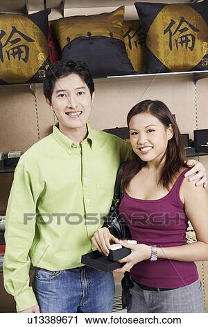 Portrait of a young couple standing in a store and smiling View Large Photo Image Stock Image - Portrait of a young couple standing in a store and smiling. Fotosearch