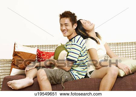 Portrait of a young man sitting back to back with a young woman View Large Photo Image Stock Image - Portrait of a young man sitting back to back with a young woman. Fotosearch