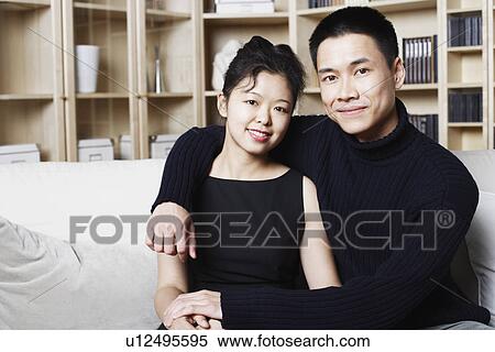 Portrait of a young man sitting with a young woman smiling View Large Photo Image Stock Photography - Portrait of a young man sitting with a young woman smiling. Fotosearch