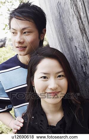 Portrait of a young woman and a young man smiling View Large Photo Image Stock Photo - Portrait of a young woman and a young man smiling. Fotosearch
