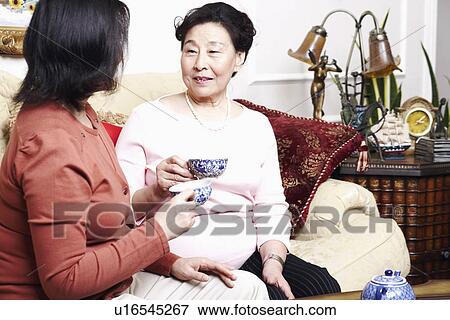 Side profile of a girl and her mother holding tea cups View Large Photo Image Stock Photo - Side profile of a girl and her mother holding tea cups. Fotosearch