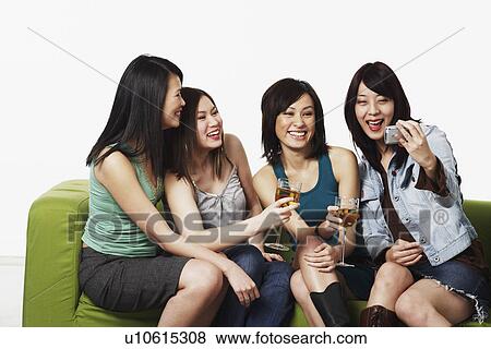 Close-up of four young women taking a photograph of themselves with a mobile phone camera View Large Photo Image Stock Photo - Close-up of four young women taking a photograph of themselves with a mobile phone camera. Fotosearch