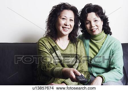 Close-up of two mature women sitting together on a couch smiling View Large Photo Image Picture - Close-up of two mature women sitting together on a couch smiling. Fotosearch