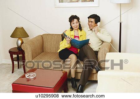 Mature man sitting on a couch with a mature woman talking on the telephone View Large Photo Image Stock Photo - Mature man sitting on a couch with a mature woman talking on the telephone. Fotosearch