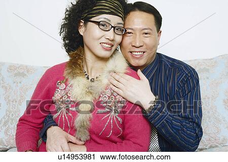 Stock Image - Portrait of a mature woman sitting with a mature man. Fotosearch