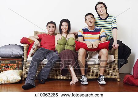 Portrait of a young couple and two mid adult men sitting on a couch and smiling View Large Photo Image Stock Photography - Portrait of a young couple and two mid adult men sitting on a couch and smiling. Fotosearch