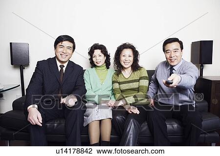 Portrait of two mature couples sitting together on a couch smiling View Large Photo Image Stock Image - Portrait of two mature couples sitting together on a couch smiling. Fotosearch
