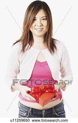 Stock Image - Portrait of a mid adult woman holding a gift. Fotosearch