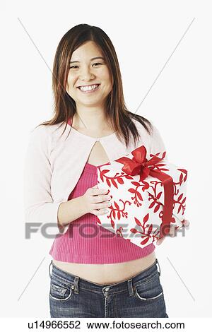 Portrait of a mid adult woman holding a gift View Large Photo Image Stock Image - Portrait of a mid adult woman holding a gift. Fotosearch