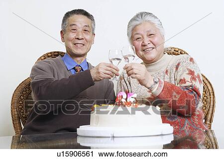 Stock Image - Portrait of a senior couple toasting with wine glasses. Fotosearch