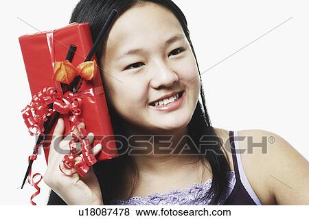 Portrait of a teenage girl holding a gift View Large Photo Image Stock Photo - Portrait of a teenage girl holding a gift. Fotosearch