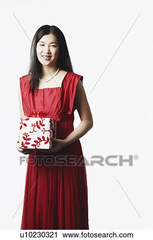 Stock Image - Portrait of a young woman holding a gift. Fotosearch
