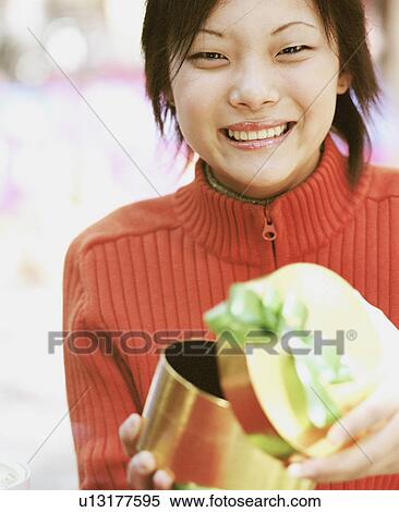 Stock Photography - Portrait of a young woman holding a gift. Fotosearch