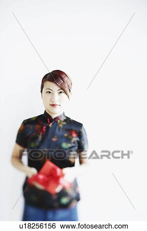 Portrait of a young woman holding a gift in her hands View Large Photo Image Stock Photograph - Portrait of a young woman holding a gift in her hands. Fotosearch