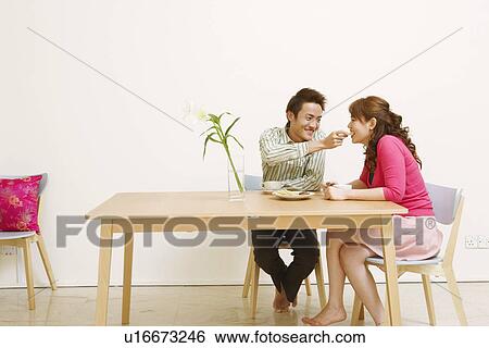 Young man feeding cookie to a young woman and smiling View Large Photo Image Stock Photograph - Young man feeding cookie to a young woman and smiling. Fotosearch