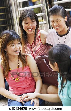 Close-up of four young women sitting and smiling View Large Photo Image Stock Photo - Close-up of four young women sitting and smiling. Fotosearch