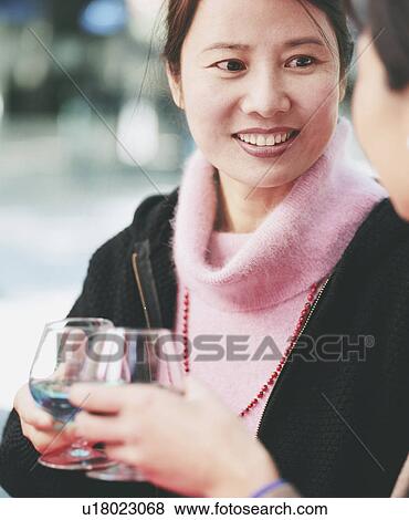 Close-up of two young women holding glasses of alcohol View Large Photo Image Stock Photo - Close-up of two young women holding glasses of alcohol. Fotosearch