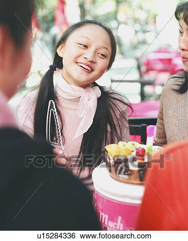 Stock Photograph - Four young women celebrating in a restaurant. Fotosearch