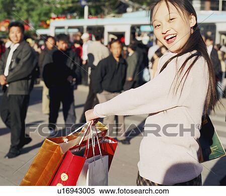 Portrait of a young woman holding shopping bags View Large Photo Image Stock Photography - Portrait of a young woman holding shopping bags. Fotosearch