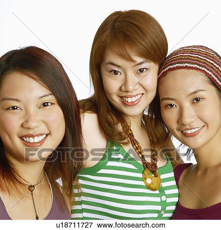 Stock Photo - Portrait of three young women posing and smiling. Fotosearch