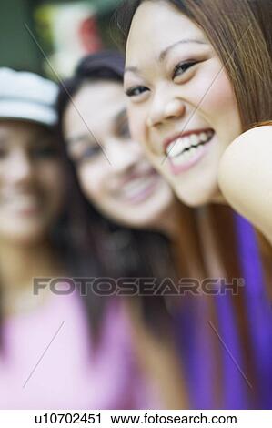 Stock Image - Portrait of three young women smiling. Fotosearch
