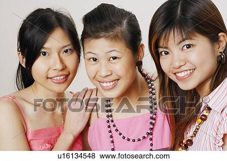 Stock Photo - Portrait of three young women smiling. Fotosearch