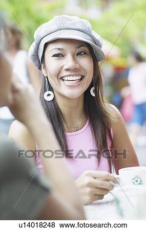 Stock Photo - Young woman sitting in an outdoor restaurant. Fotosearch