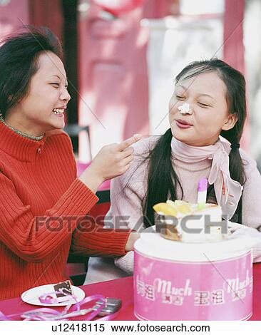 Stock Photography - Young woman smiling at another woman. Fotosearch