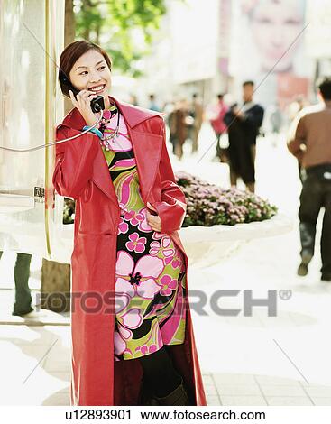 Young woman talking on a pay phone View Large Photo Image Stock Image - Young woman talking on a pay phone. Fotosearch