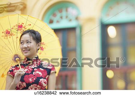 Close-up of a young woman holding a parasol View Large Photo Image Stock Image - Close-up of a young woman holding a parasol. Fotosearch