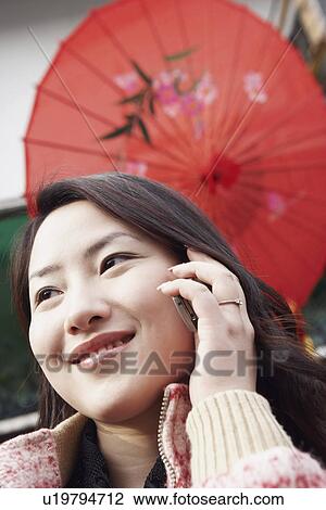 Stock Image - Close-up of a young woman using a mobile phone. Fotosearch
