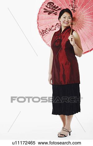 Mid adult woman holding a parasol View Large Photo Image Stock Photography - Mid adult woman holding a parasol. Fotosearch