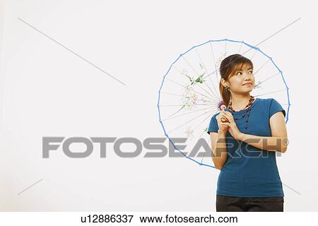 Young woman holding a parasol and smiling View Large Photo Image Stock Photo - Young woman holding a parasol and smiling. Fotosearch