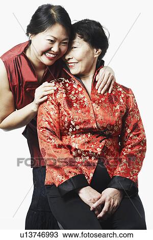 Stock Image - Close-up of a girl standing behind her mother. Fotosearch